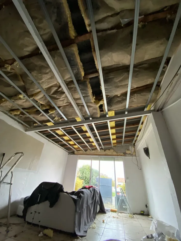 Travaux en cours  installation d'une ossature métallique suspendue et pose d'isolant
