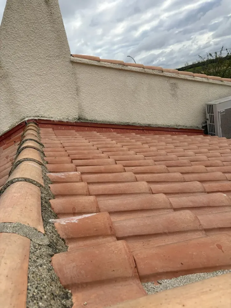Détail d'une jonction complexe de toiture  condensation sur un lanterneau vitré à cadre métallique intersecting une façade crépie avec une soline d'étanchéité