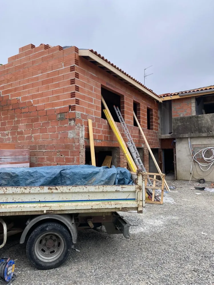 Un camion garé devant une maison, avec un jardin bien entretenu en arrière-plan